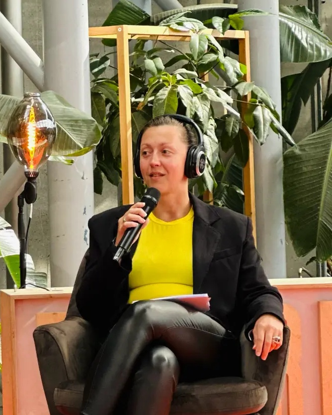 Sara Storm on stage with a microphone at a GTM panel