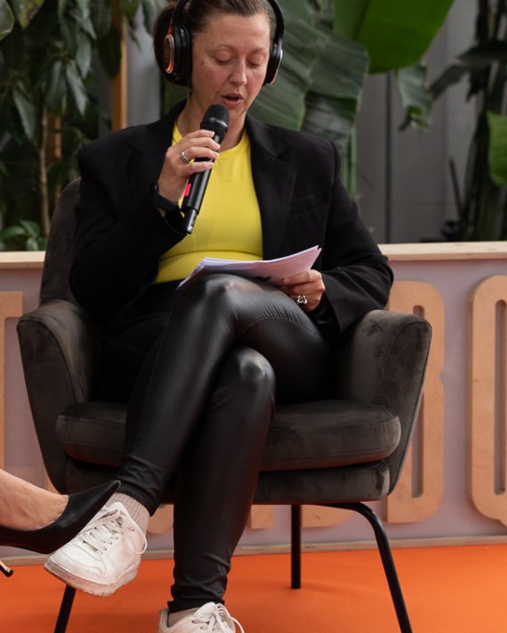 Sara Storm speaking with a microphone at an N.Rich GTM panel